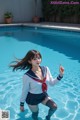 A woman in a sailor outfit standing in a pool.