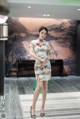 A woman in a cheongsam poses for a picture.