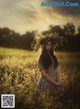 A woman standing in a field with a wreath on her head.