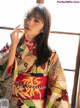 A woman in a colorful kimono smoking a cigarette.