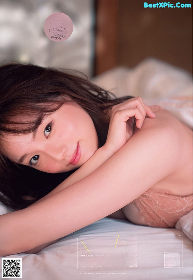 A woman laying on top of a bed in lingerie.