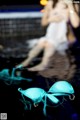 A woman in a white dress sitting on top of a pool.