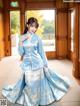 A woman in a blue and white hanbok is posing for a picture.