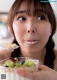 A woman holding a bowl of food with a spoon in it.