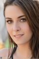 A beautiful young woman with long brown hair posing for a picture.